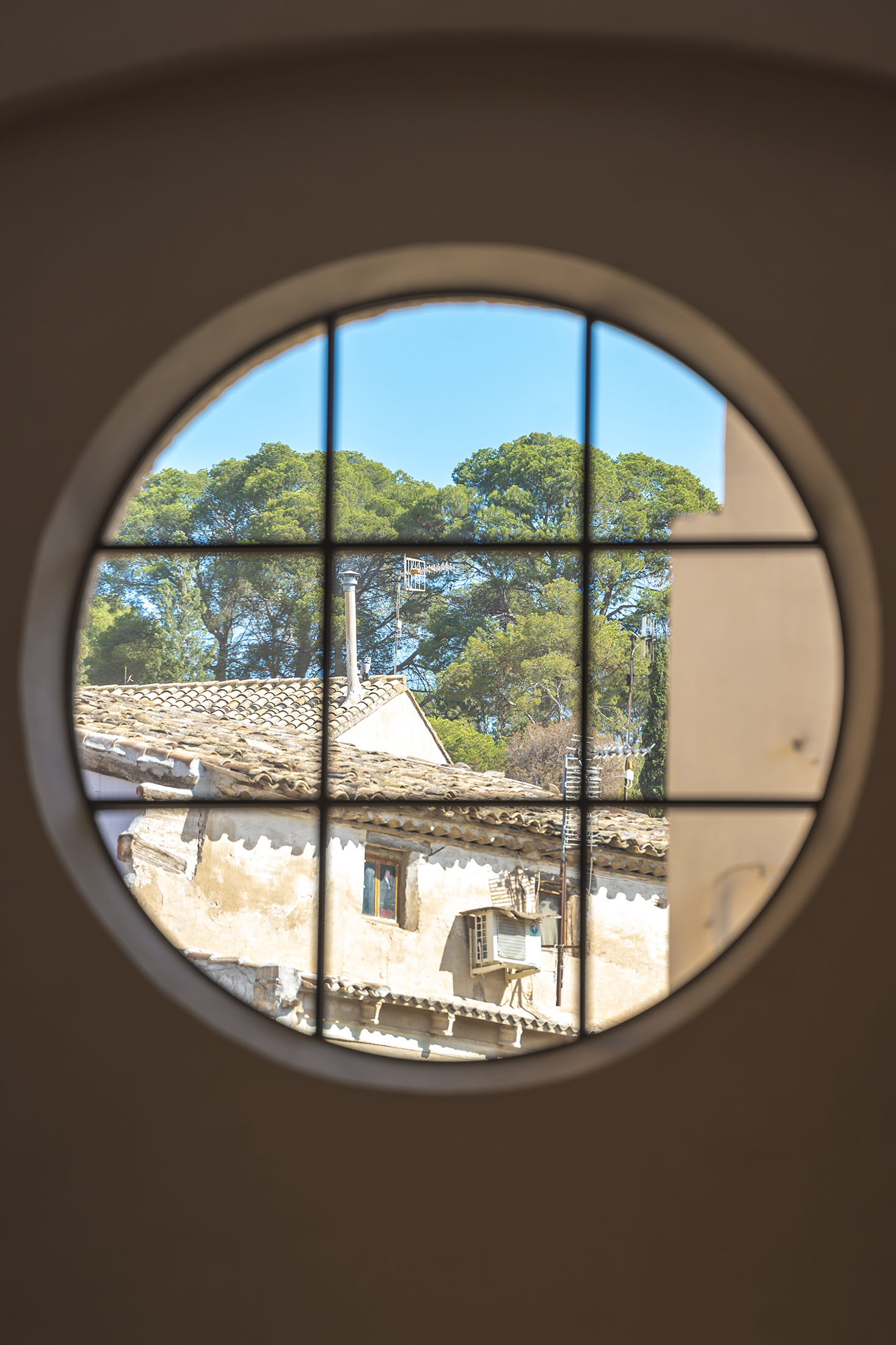 Vista del paisaje exterior a través del óculo circular con nueva carpintería metálica
